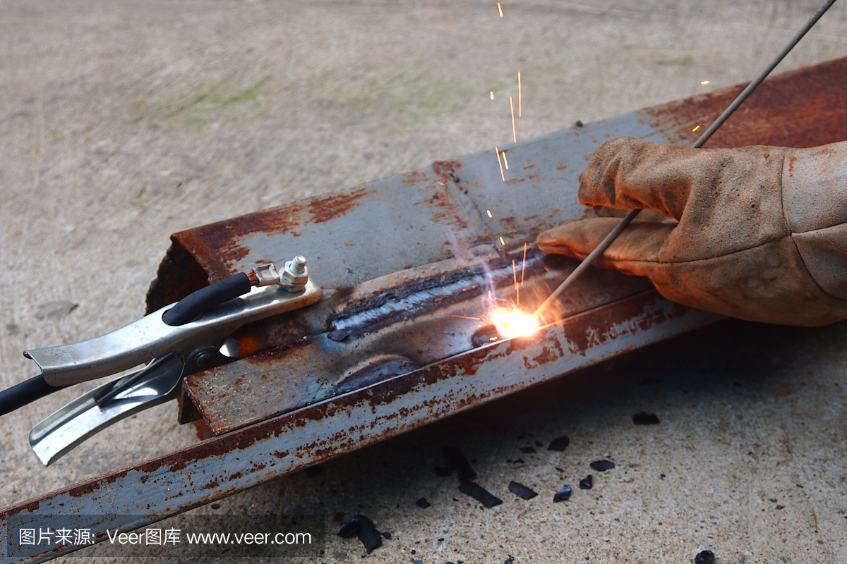 焊工焊接金属。明亮的电弧和火花